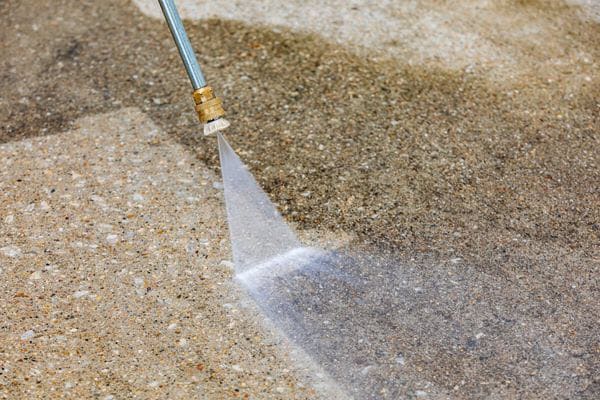 Exposed Aggregate Concrete Getting Hosed With Pressure Cleaner